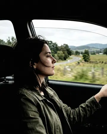 A fictional passenger looking out of a car window, daylight outside. With the Cinema Grade preset applied.