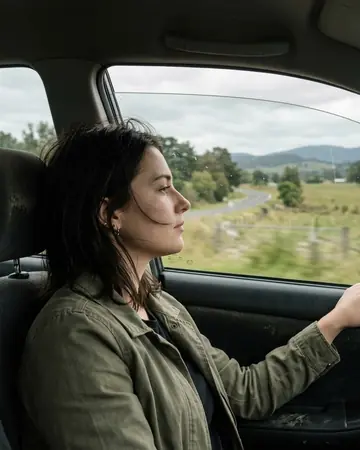 A fictional passenger looking out of a car window, daylight outside. Photographed without a preset.