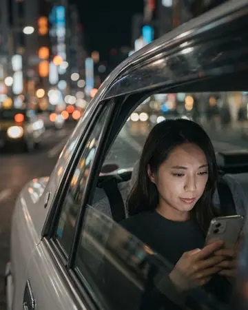 View through a taxi window at night, city lights bokeh, fictional passenger's face lit by the phone. Photographed without a preset.