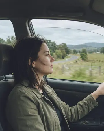 A fictional passenger looking out of a car window, daylight outside. With the Japan Film preset applied.