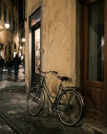 A bicycle leaning on a painted wall beside a doorway, night, lit only by street and shop lights. Photographed without a preset.
