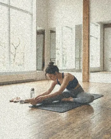 A fictional dancer stretching in a bright studio, daylight. With the Pastel Film preset applied.