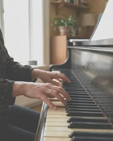 A fictional pianist's hands on the keys, room light. With the Pastel Film preset applied.