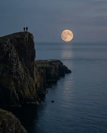 A full moon rising over sea cliffs at dusk, calm sea, a fictional couple as tiny silhouettes on the edge. Photographed without a preset.