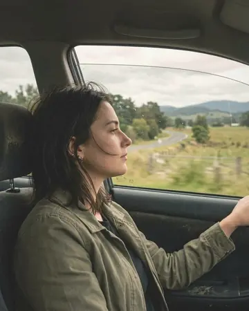 A fictional passenger looking out of a car window, daylight outside. With the Warm Negative preset applied.